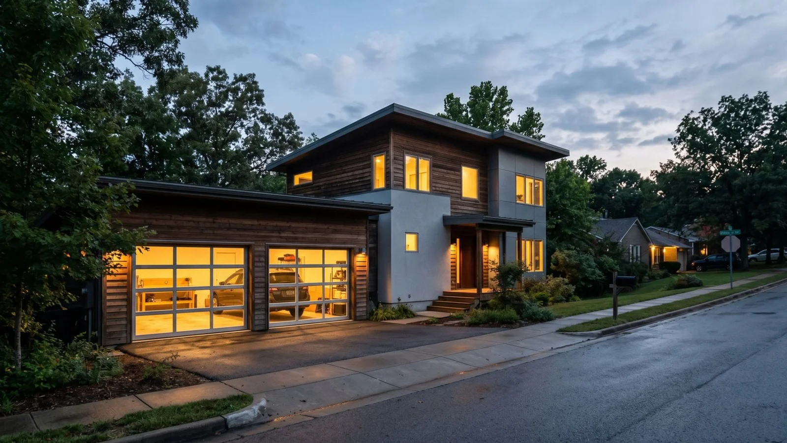 Modern home with illuminated glass garage door at dusk